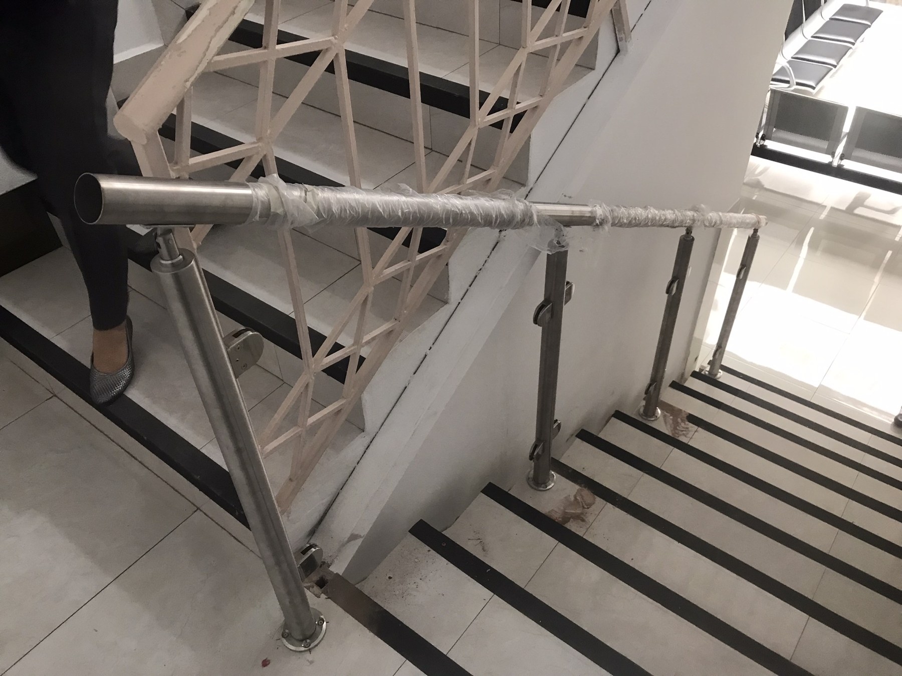 Detalle de barandal de cristal con herrajes de acero en escalera